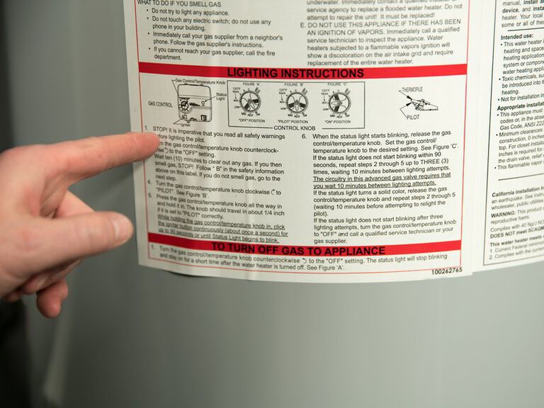 hand pointing to instruction panel on the back of a water heater hand pointing to instruction panel on the back of a water heater